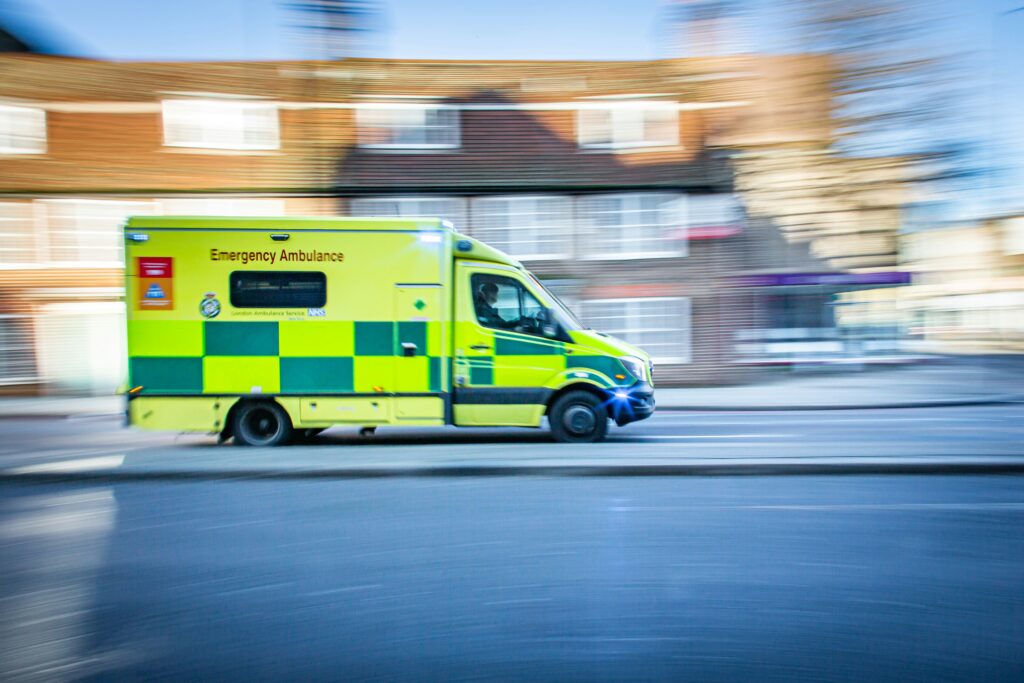 An NHS ambulance moving at speed